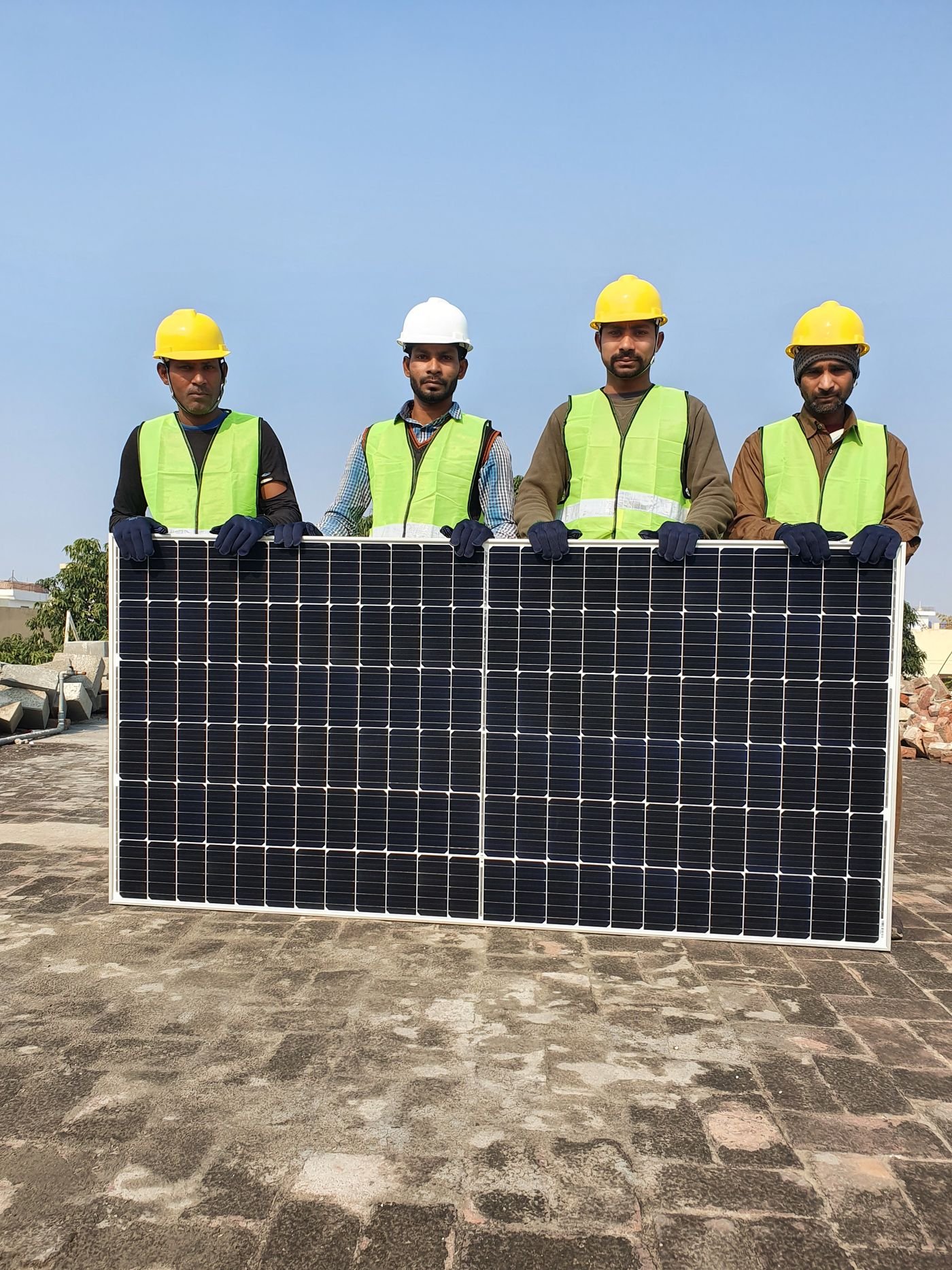 Solar installation team holding a solar panel on a rooftop